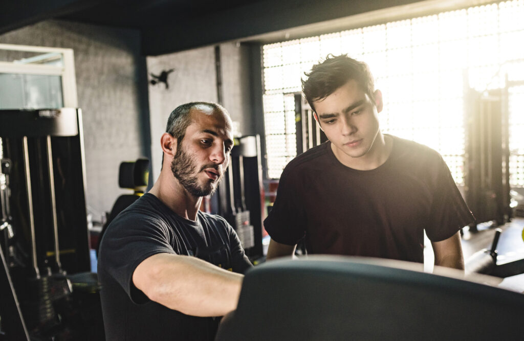 Personal trainer showing weight training equipment